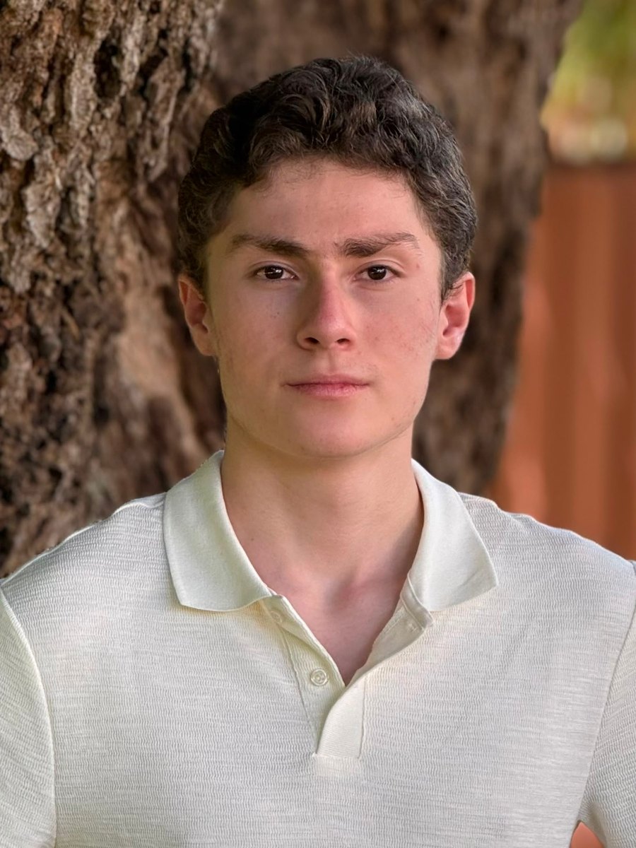 Daniel Llobet outdoors in a cream polo shirt, standing in front of a tree.